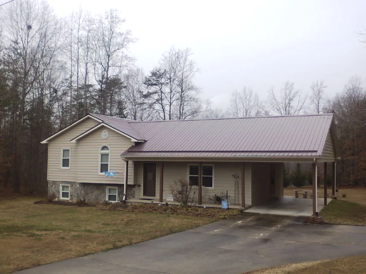 Burgundy metal roof on a tan split level home with an attached carport in Smithfield